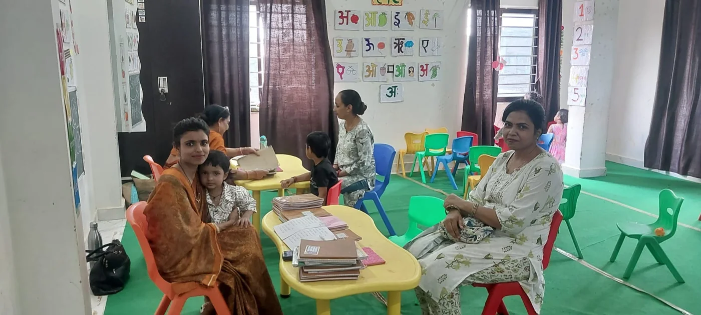 Teachers and children seated at colourful low tables in a Wonder Bees classroom